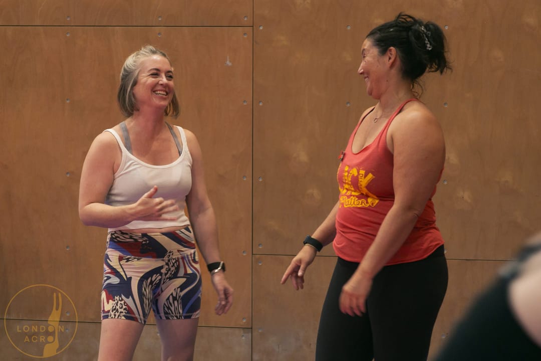 Ariel wearing red vest smiling at Kasey wearing white vest