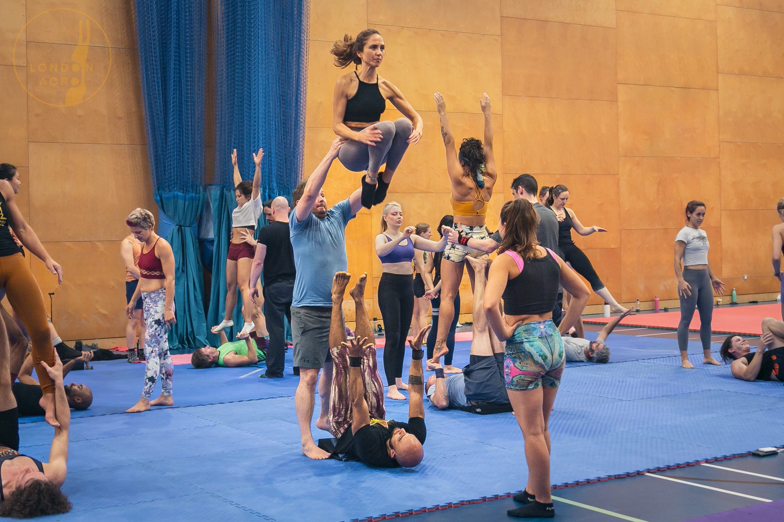 3 people performing an Icarian Chair pop at an acro yoga convention