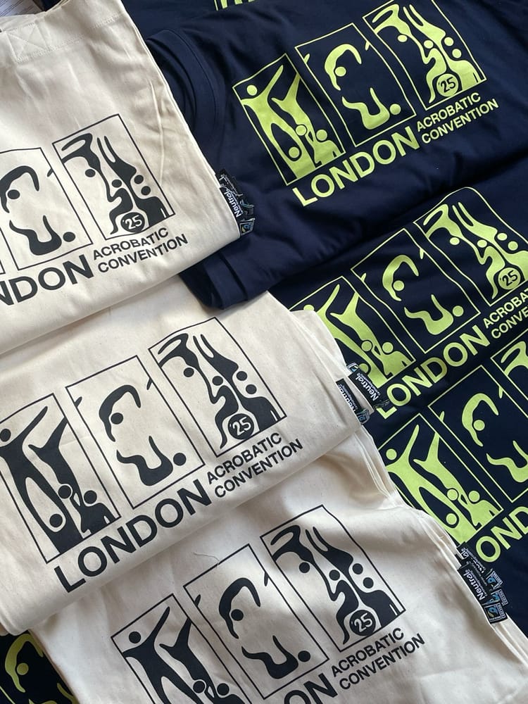 LAC 2025 canvas tote bags with black graphic next to navy LAC 2025 vests/t-shirts with lime green graphic laid out folded in two columns